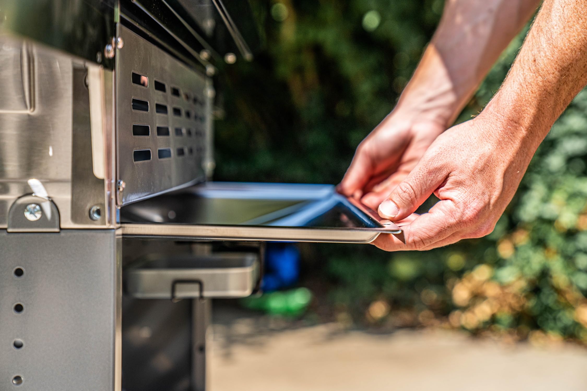 Monument Grills A110 in outdoor setup demonstrates grease collection and flare-up control.
