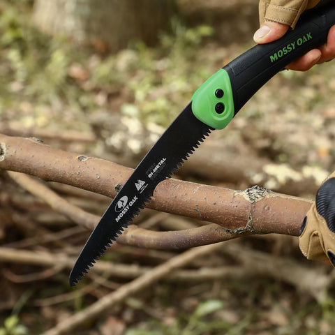 Mossy Oak folding saw in outdoor use, ready for hunting and camping tasks.