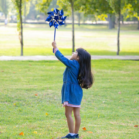 Muka blue pinwheel kids playing evokes motion and safe outdoor play.