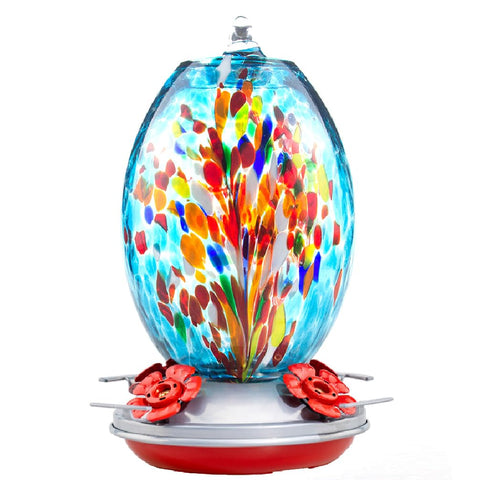 Muse Garden glass hummingbird feeder with blue fireworks hangs on a tree to attract hummingbirds
