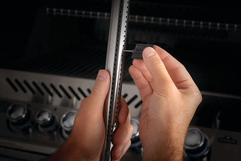 Napoleon gas grill cleaning toolset neatly stored for quick access.