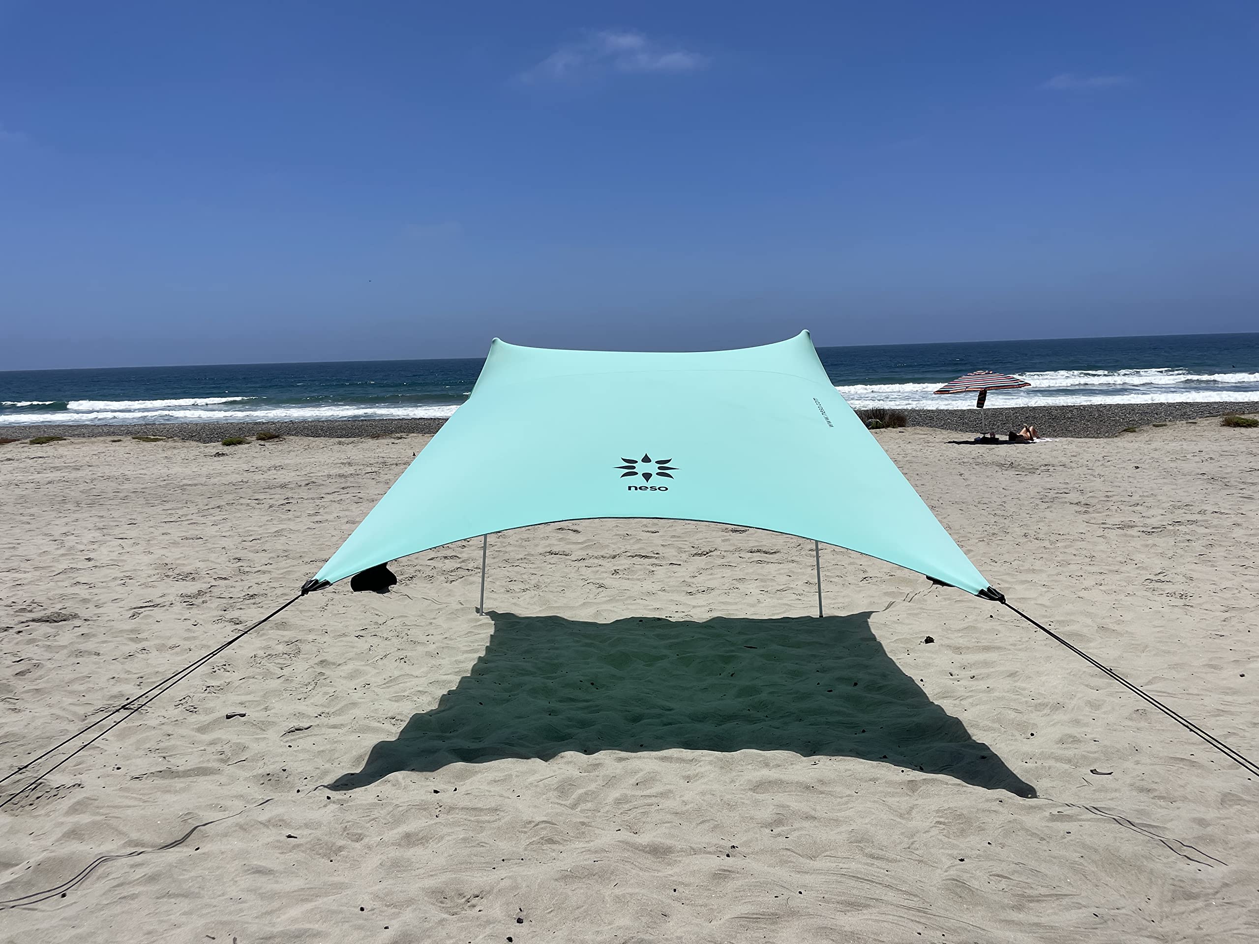 Neso portable beach tent seafoam provides lightweight shade for family days by the shore.