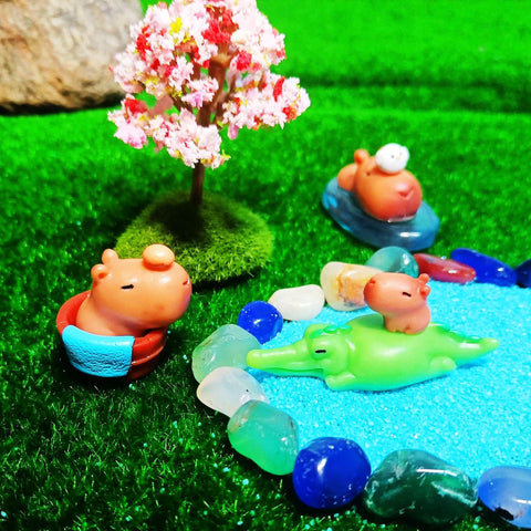 Niberda moss balls with figures enhance potted plant décor.