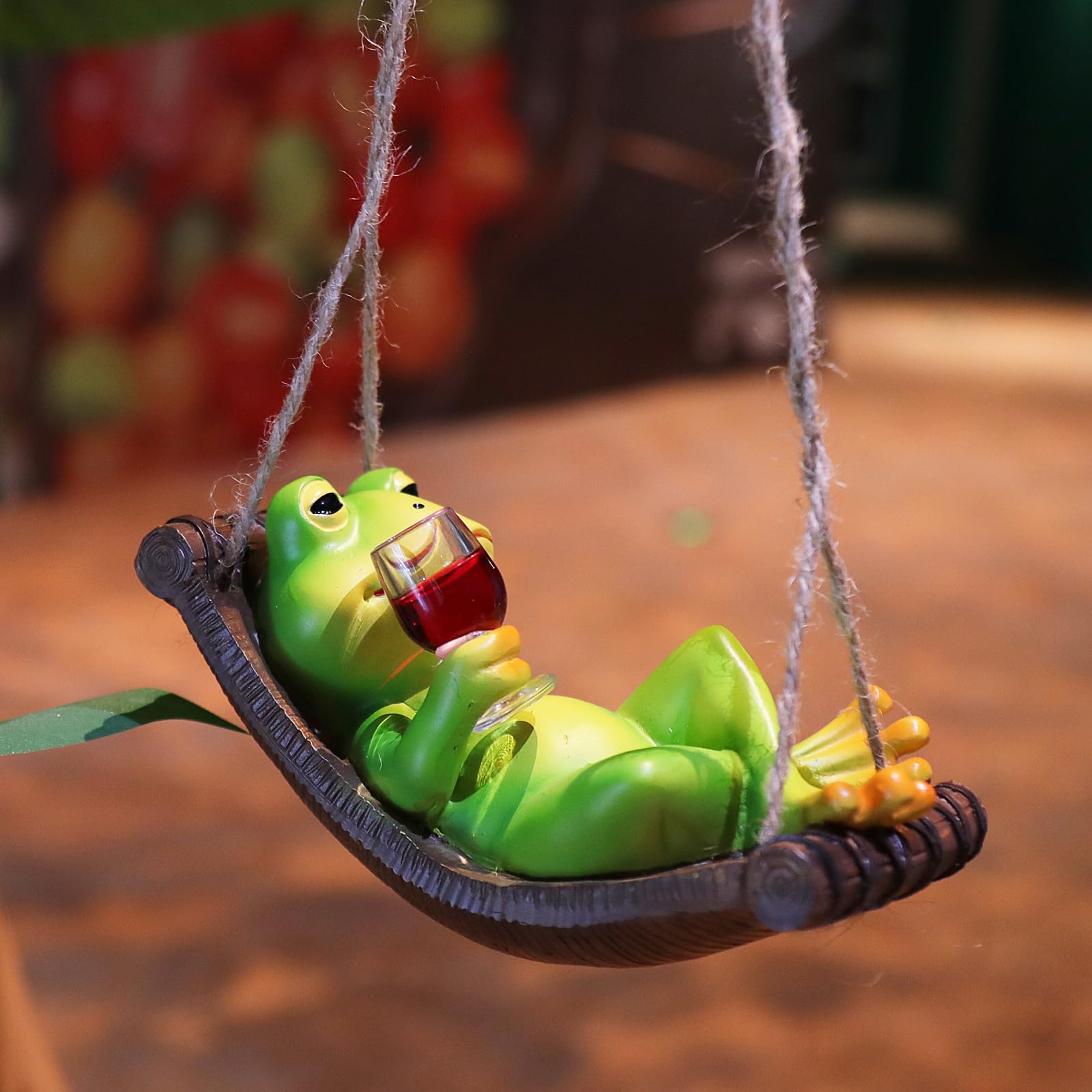 NINIPAPA hanging frog wine statue creates a whimsical focal point outdoors.