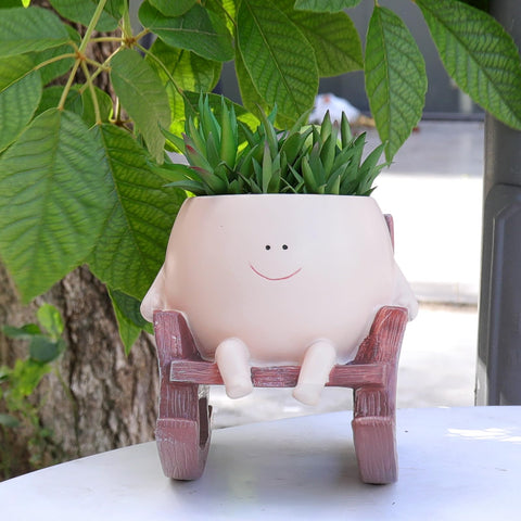 NINIPAPA smiley face planter with rocking chair on display enhances living room decor.