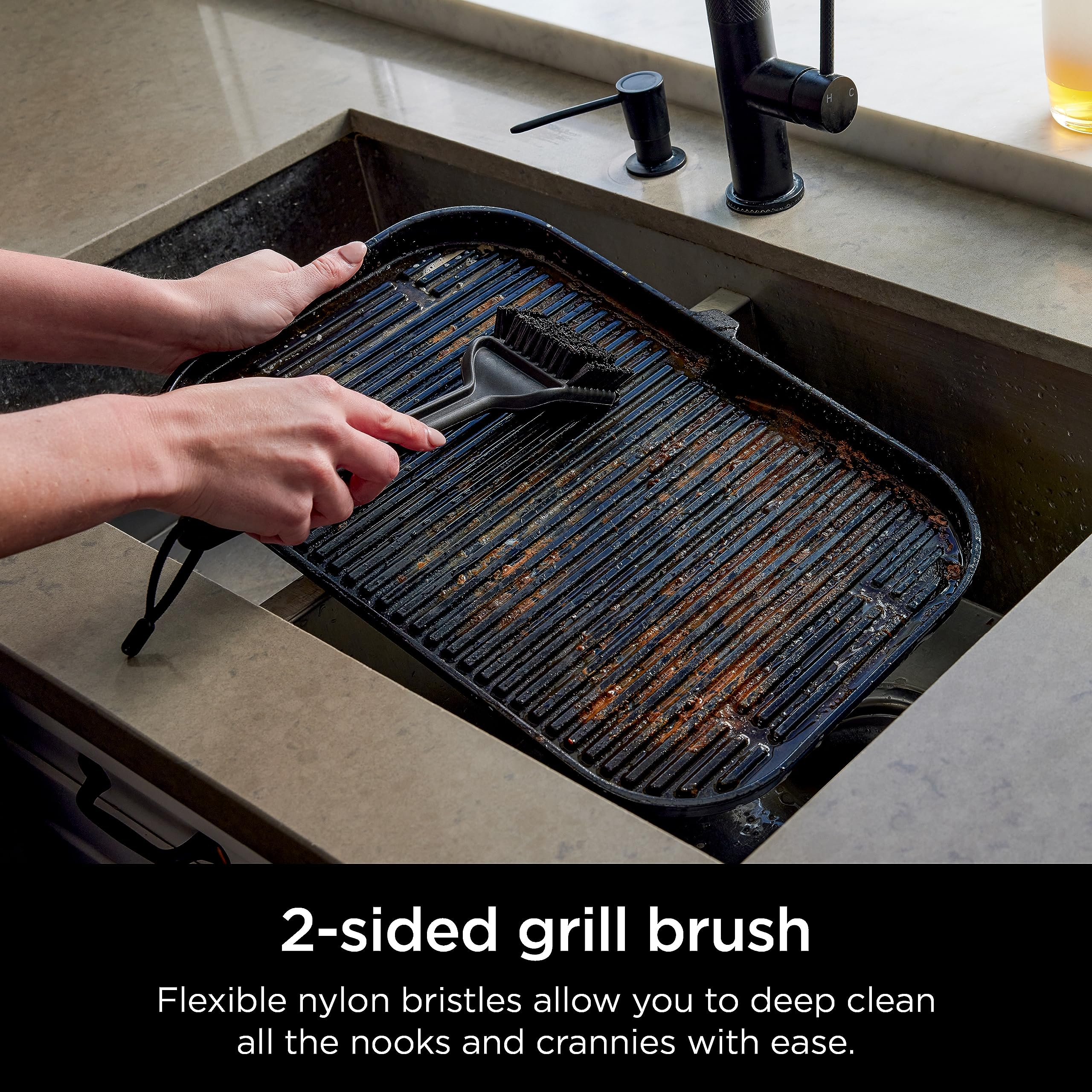 Ninja XSKBRUSHXL scraper fitting around grill grates to remove debris.