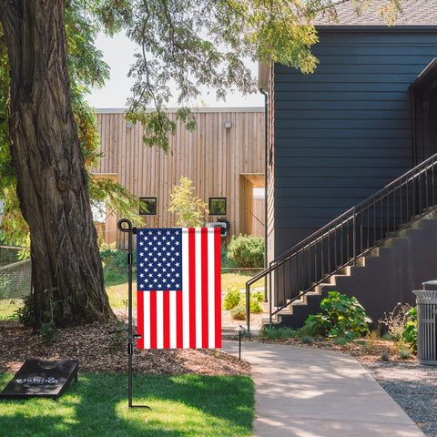 Nirohee metal banner flagpole outdoors, ideal for seasonal yard decorations.