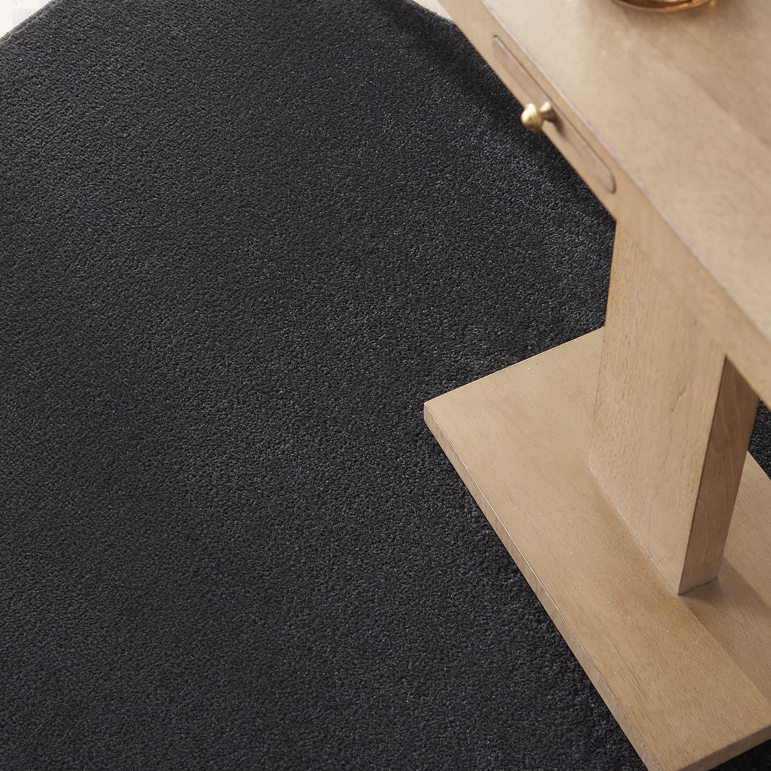 Nourison Essentials Black low-pile rug ideal for high-traffic rooms.