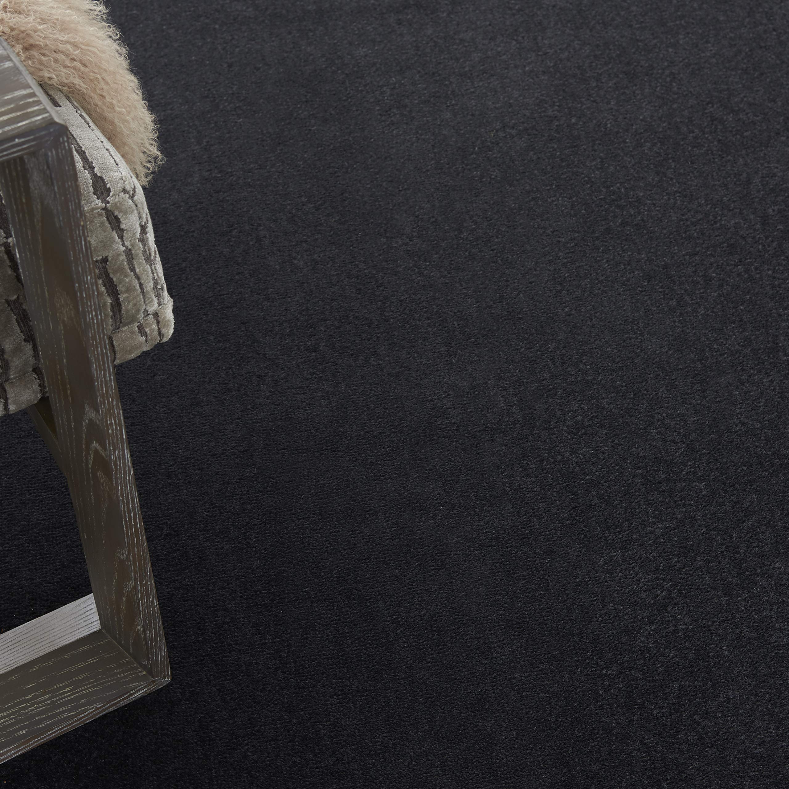Nourison Essentials black rug edge-serged for a clean, durable border.