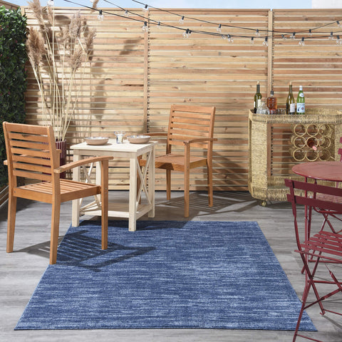 Nourison Essentials navy blue 5x8 rug in dining room setup