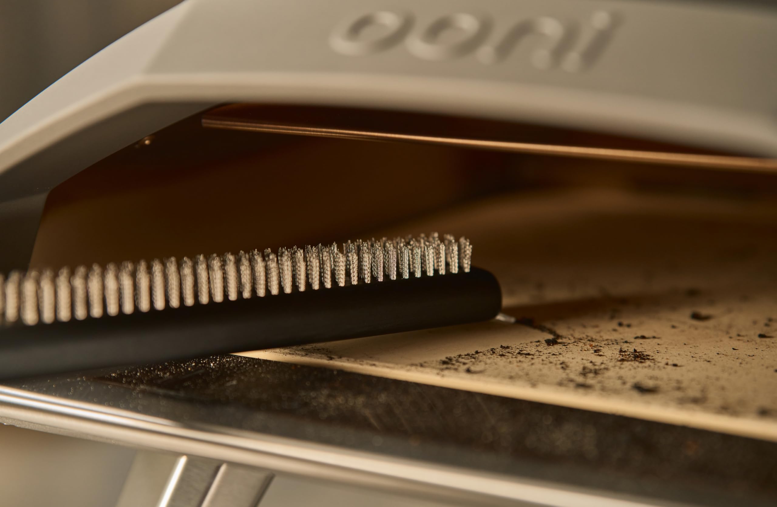 Ooni stone-cleaning action removes ash and residue from pizza stone surface.