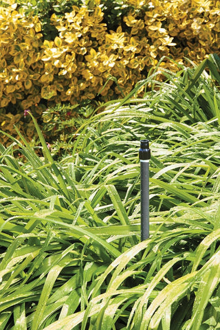 Orbit Watermaster quarter-circle sprinkler head during installation in a garden.