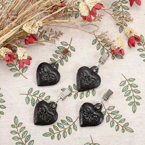 OwnMy heart-pendant tablecloth weight emphasizes vintage styling and fabric stability.