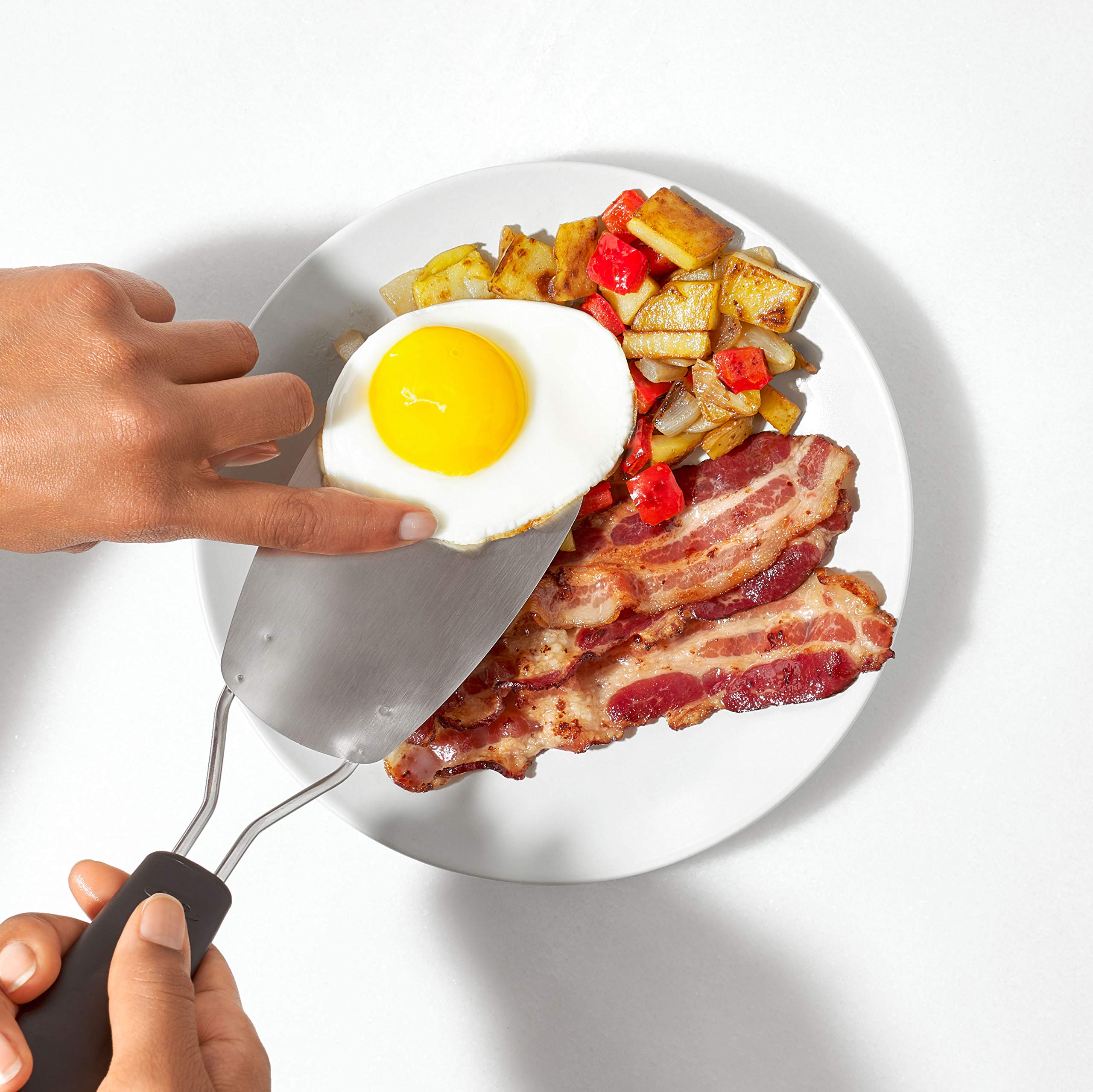 OXO Good Grips Flexible Turner in hand over pan, ergonomic grip for comfortable control