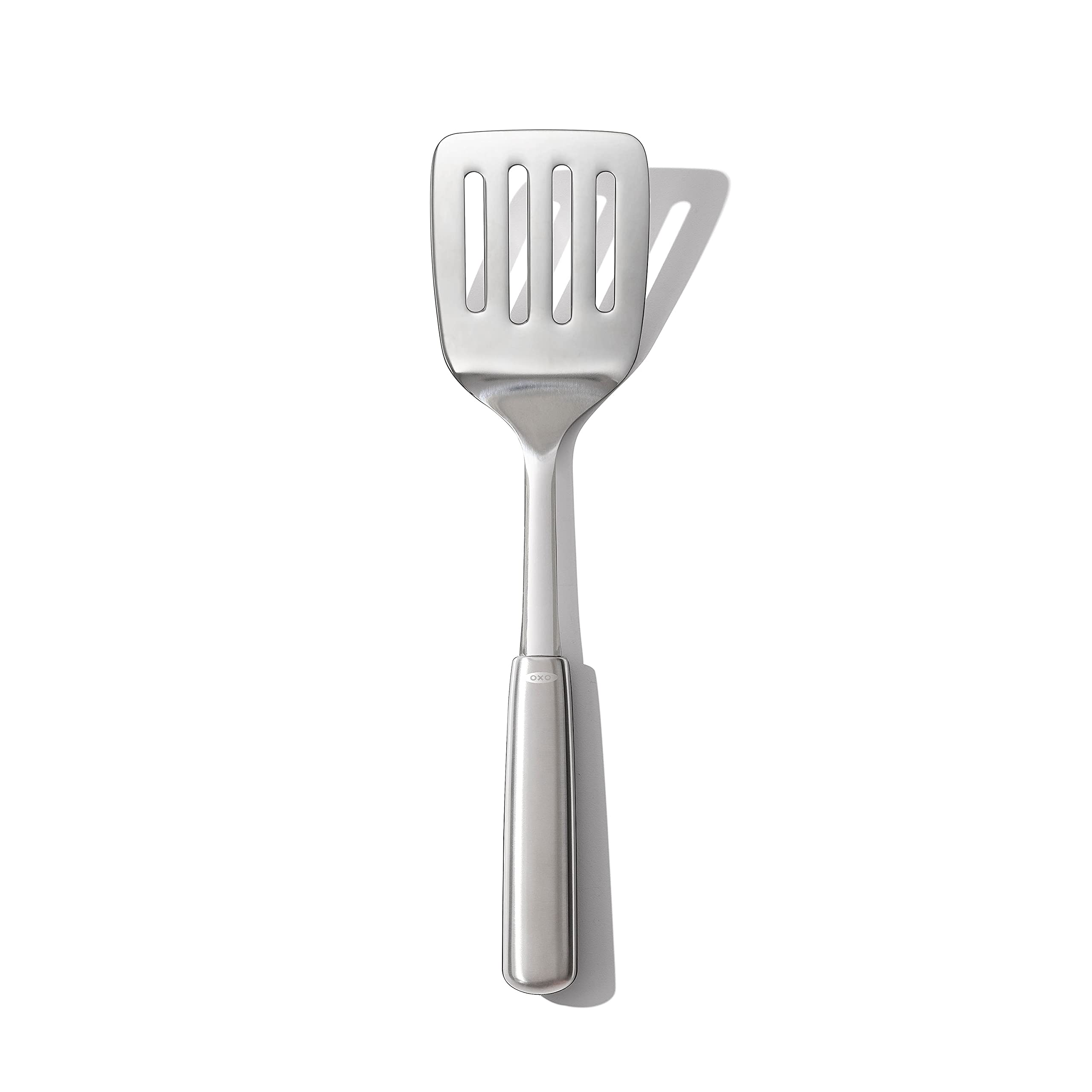 OXO Steel Cooking Turner head close-up showing sturdy flexibility for easy flipping.