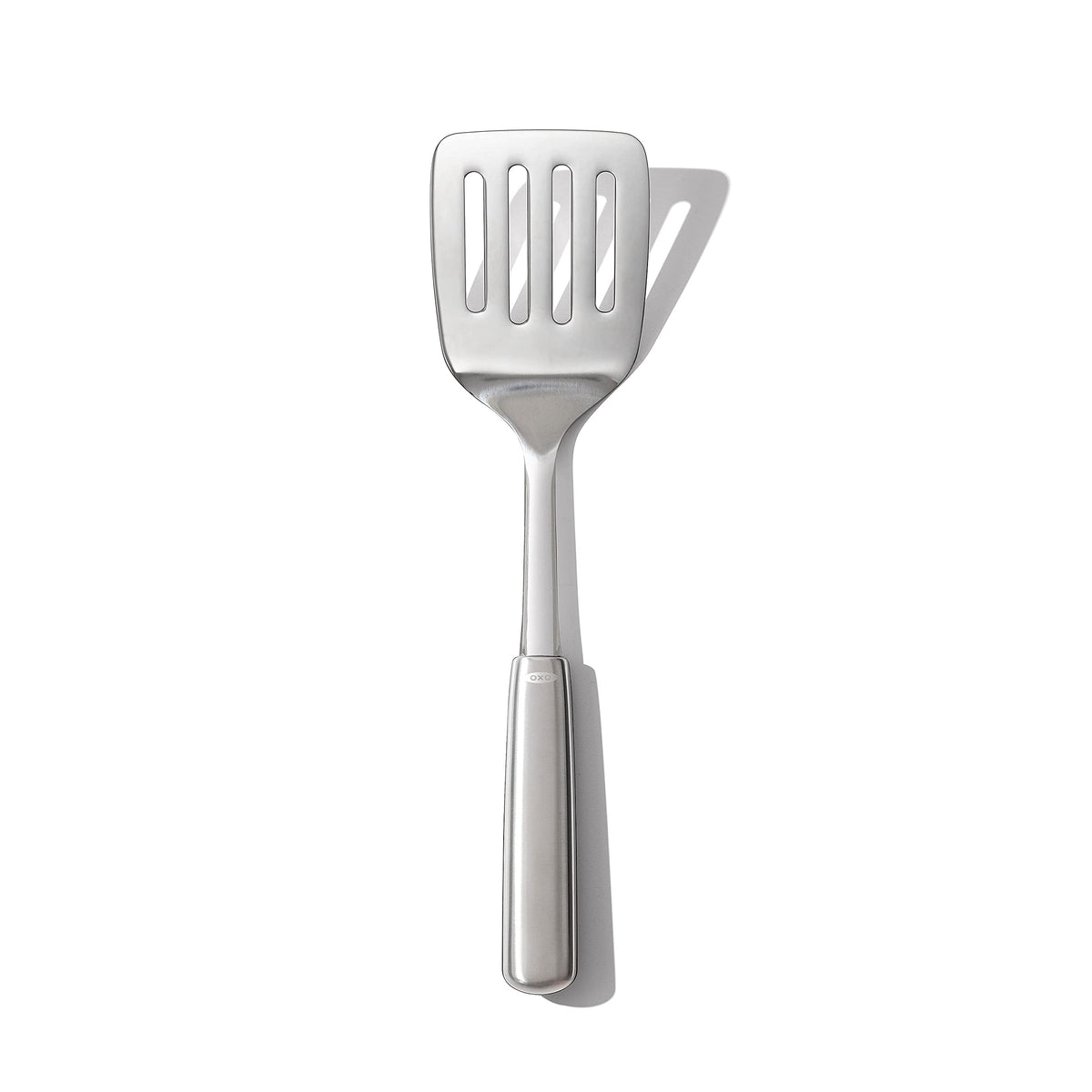 OXO Steel Cooking Turner head close-up showing sturdy flexibility for easy flipping.
