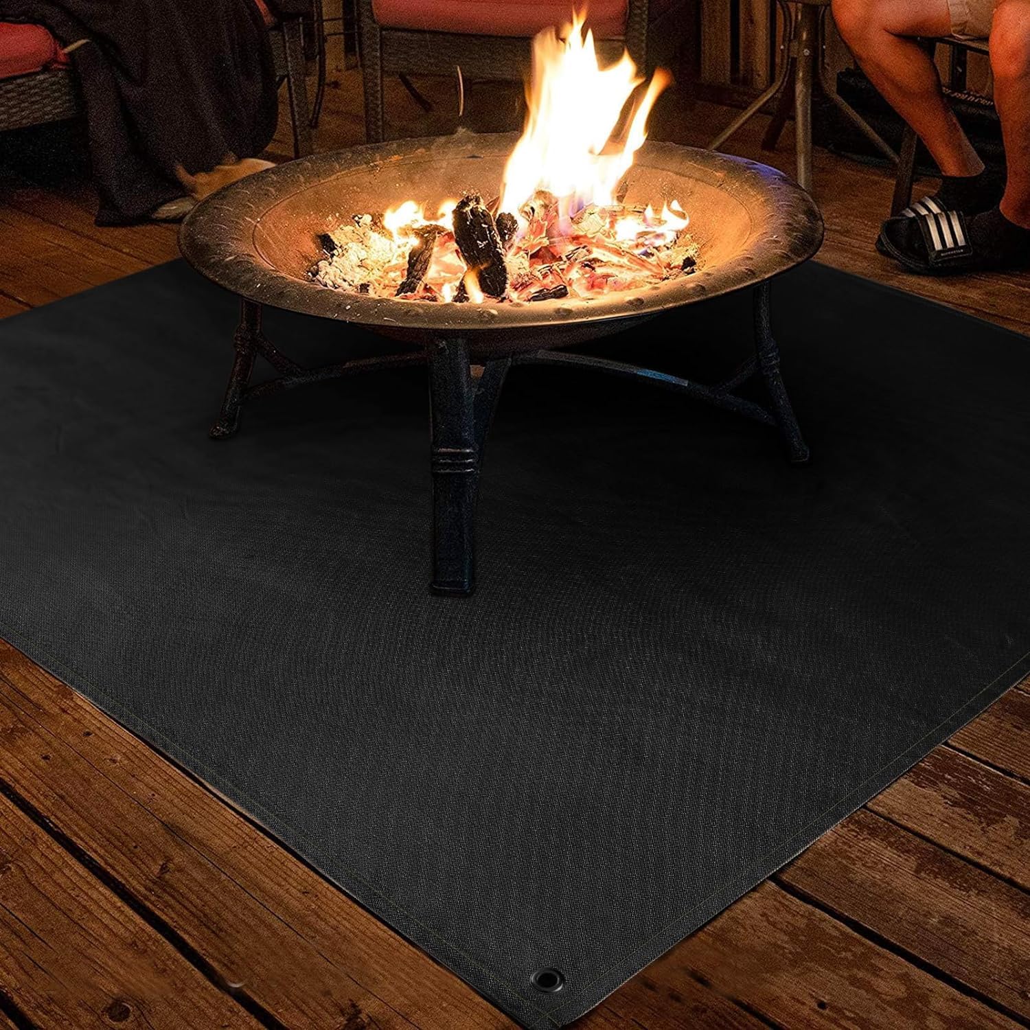 PAMASE fire pit mat corner holes secured with ground nails.
