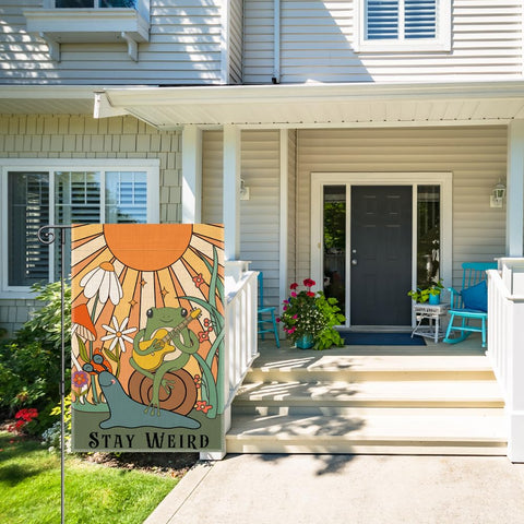 Perfectinsoy Stay Weird flag on porch and lawn welcomes guests.