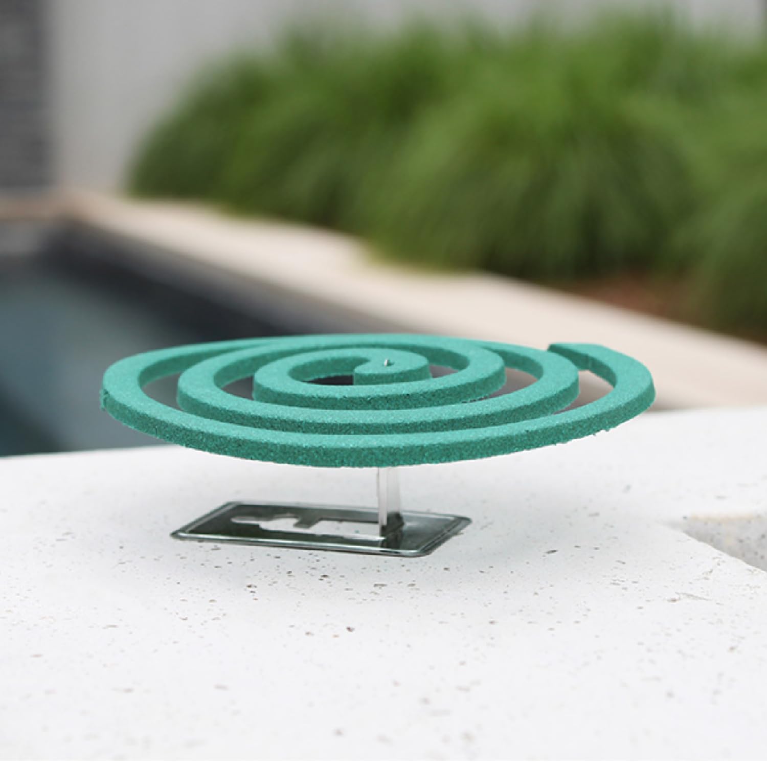 PIC Mosquito Repelling Coils burning on a stand in outdoor patio