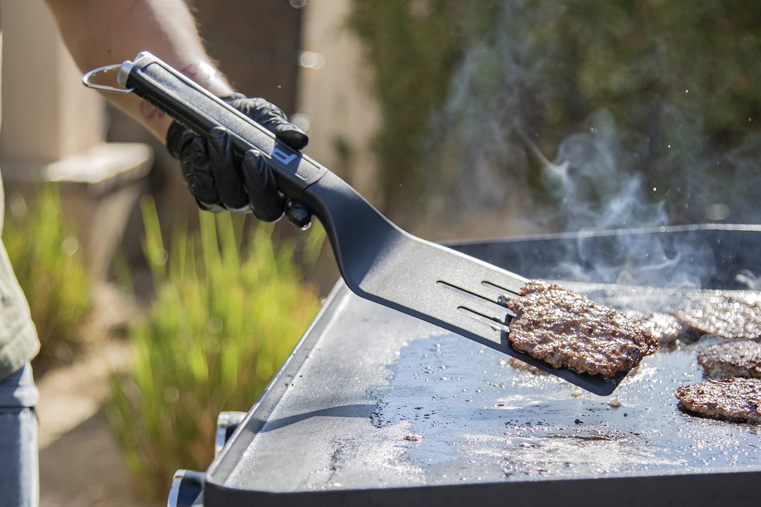 Pit Boss Ultimate griddle scraper with bottle opener end for beverages