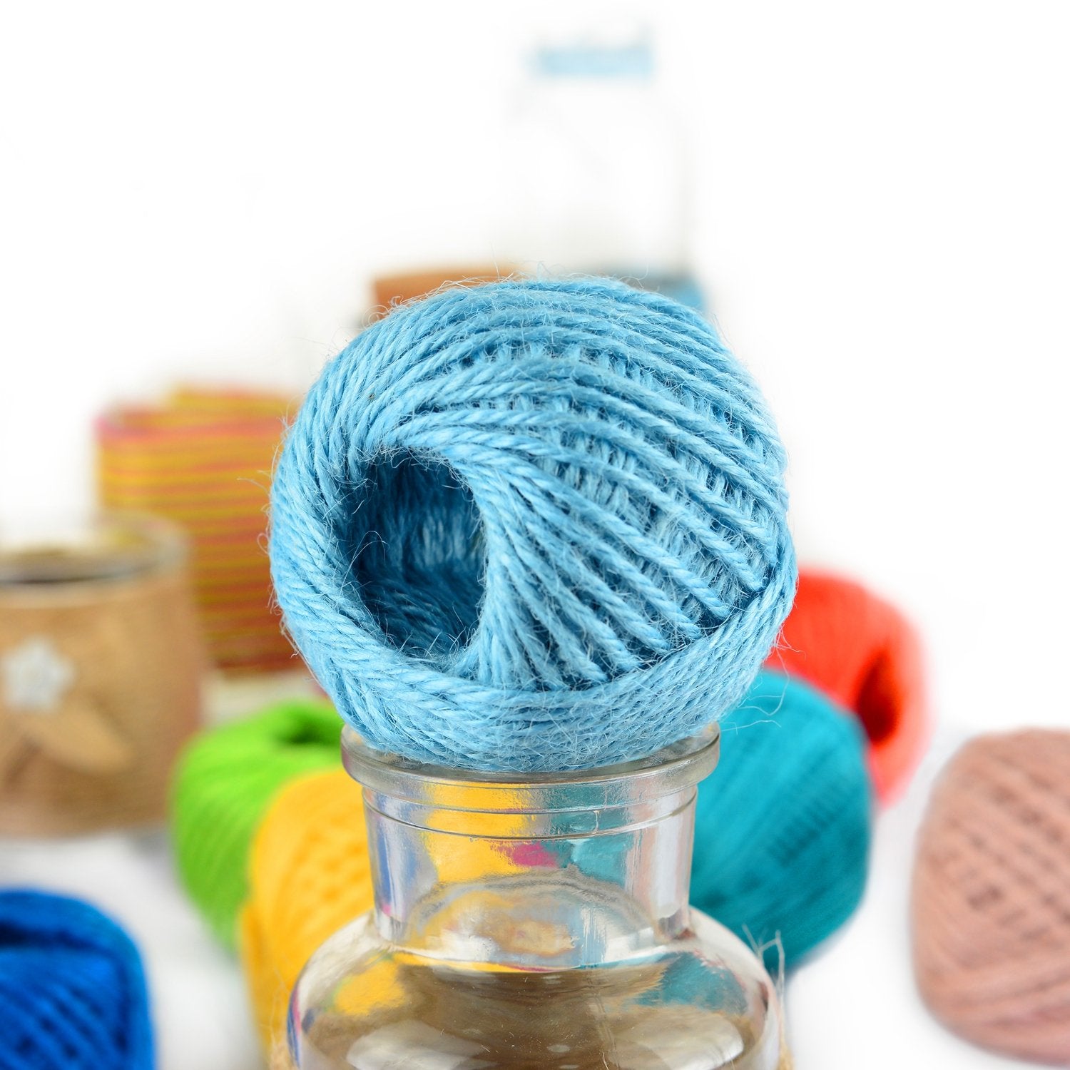 Quotidian colorful jute twine used to embellish vases with a handmade look