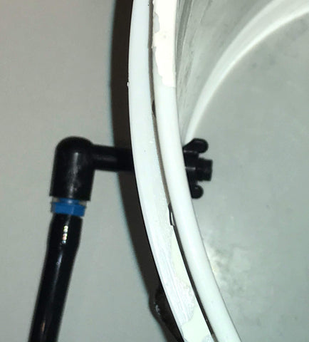 Clear drilling guide showing hole placement 1-2 inches from bucket bottom