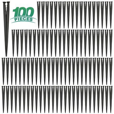 RedChili 100-pack drip stake on ground secures 1/4-inch tubing for tidy irrigation.