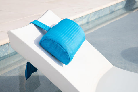 REZVANI headrest pillow on poolside furniture under sun.