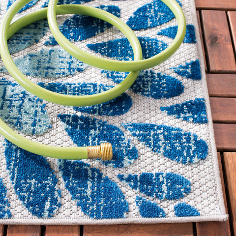 Safavieh Cabana rug in backyard dining space showcases simple hose-cleaning.