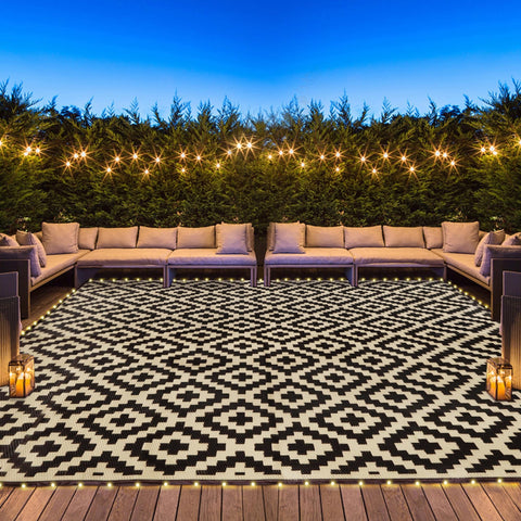 SAND MINE reversible mats with LED lights glow on a patio at dusk