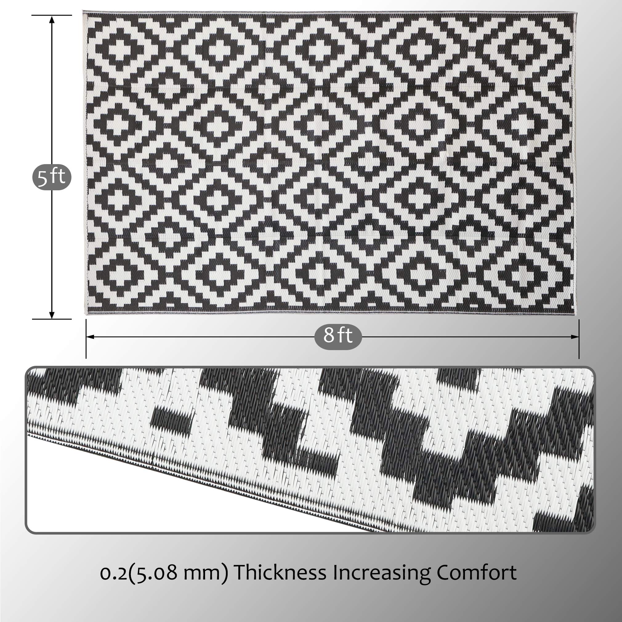 SAND MINE reversible plastic rug enhances outdoor decor with bold black and white pattern.