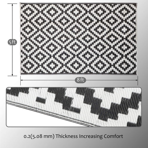 SAND MINE reversible plastic rug enhances outdoor decor with bold black and white pattern.
