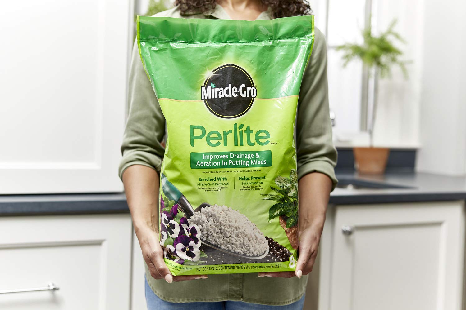Scotts Miracle-Gro Perlite is being poured into a potting mix for better aeration.