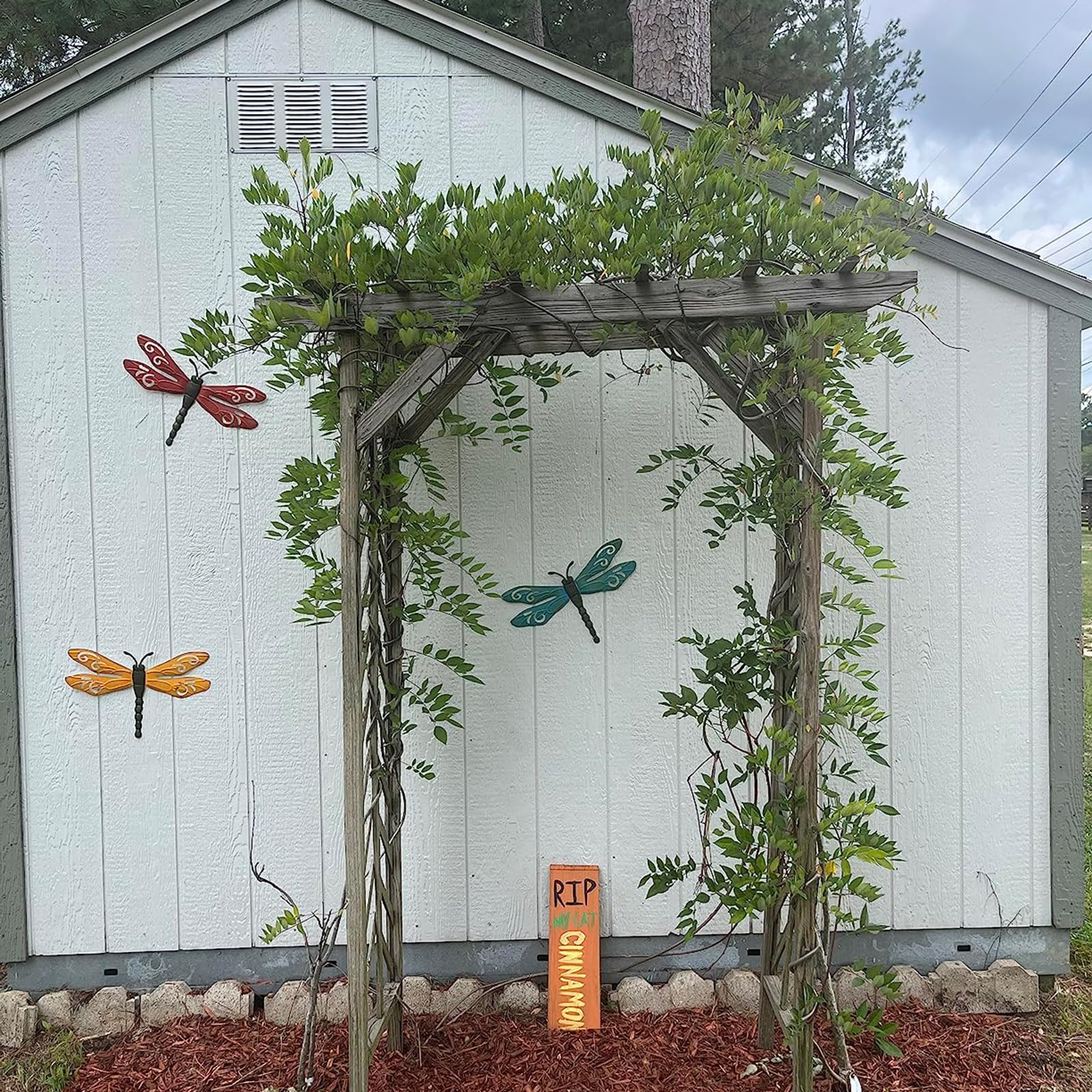 Three dragonfly ornaments arranged for outdoor garden charm.