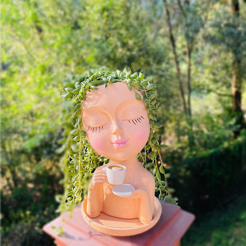 Simabsie coffee-holding face planter adds whimsy to desk decor and plant display.