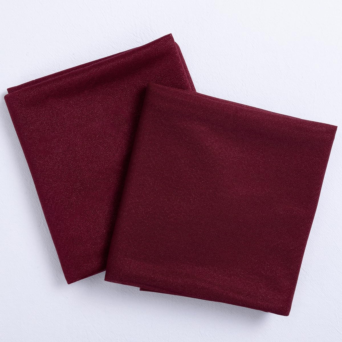 Socomi burgundy sheer arch-draping fabric closeup highlights silky texture and wrinkle-free finish.