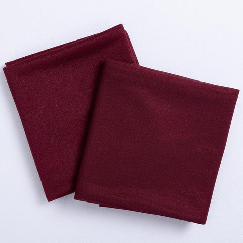 Socomi burgundy sheer arch-draping fabric closeup highlights silky texture and wrinkle-free finish.