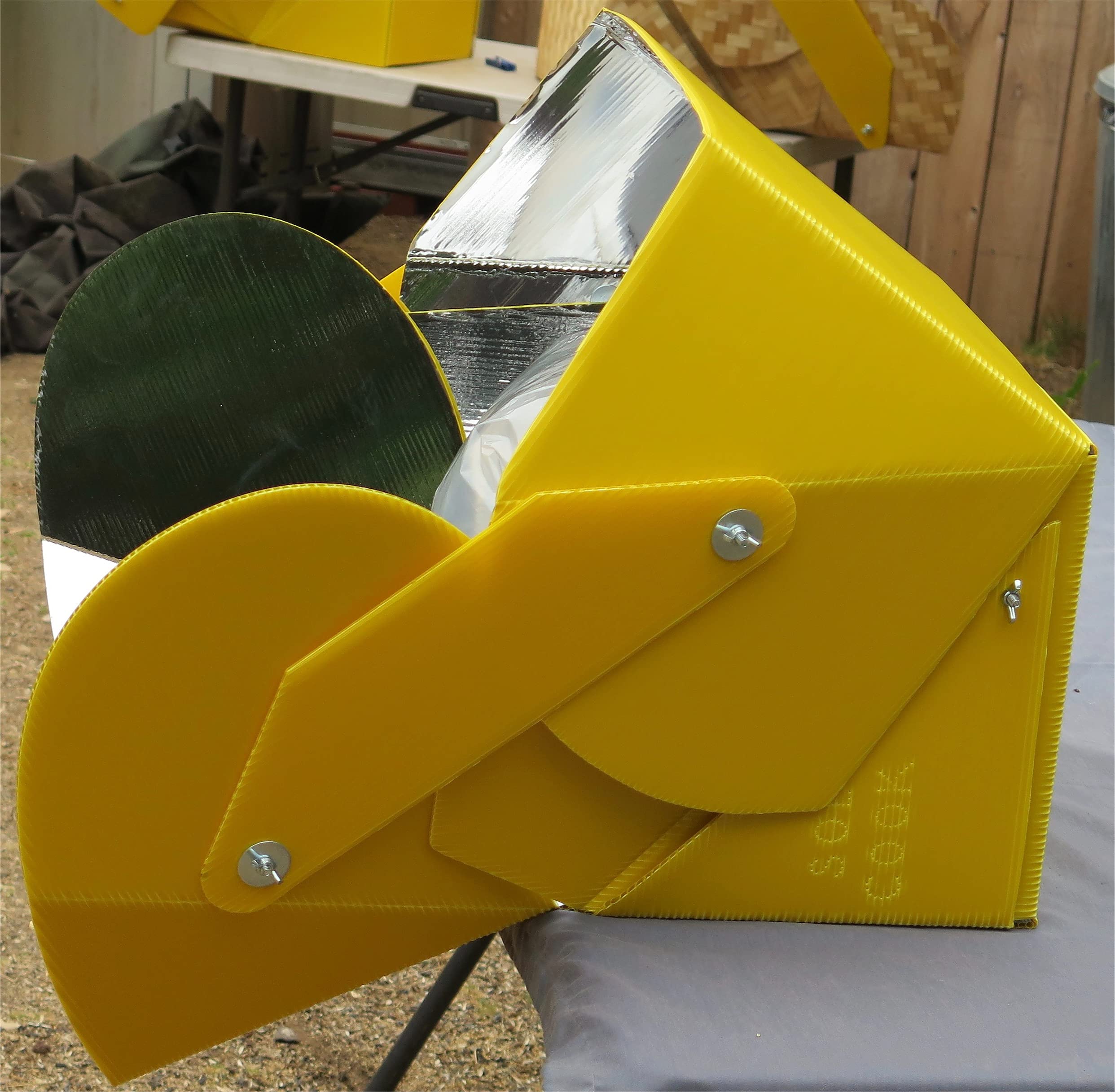 SOL COOK solar cooker alongside camping gear illustrating versatile outdoor cooking.