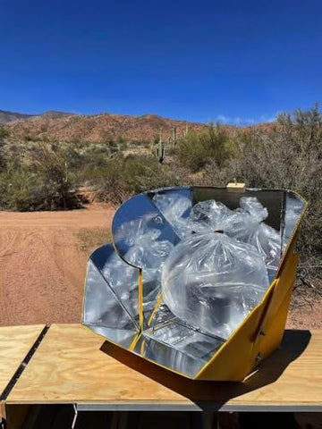 SOL COOK solar cooker in sunlight powering outdoor meals.