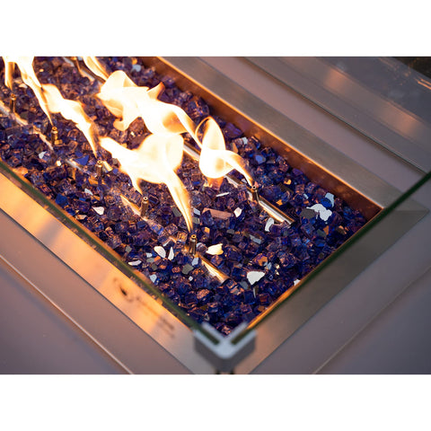 Stanbroil cobalt blue reflective fire glass creating ambient glow outdoors.