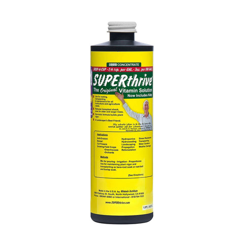 SUPERthrive plant vitamin solution bottle beside thriving houseplants for vitality.