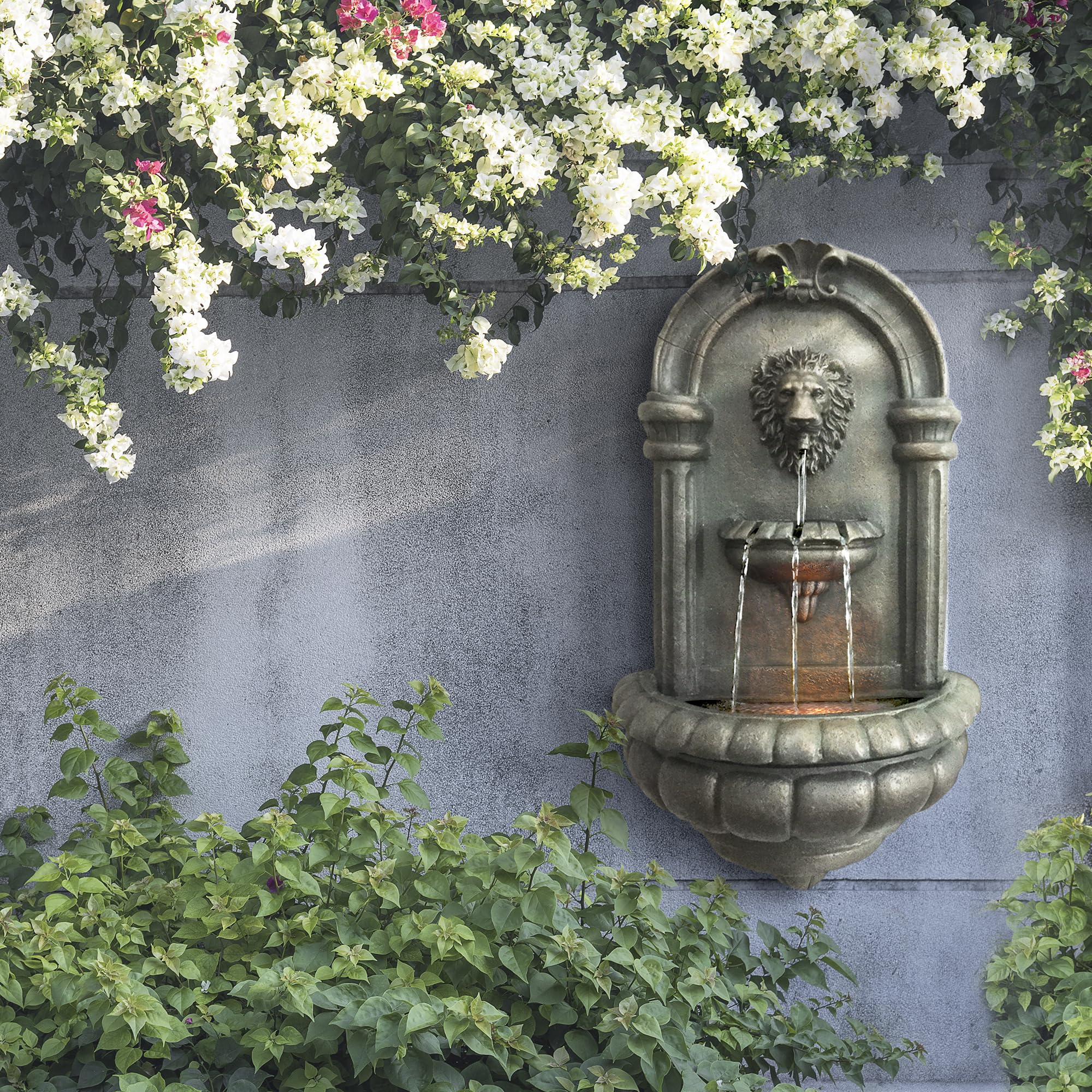 Teamson Home Lion Head Wall Fountain LED lighting highlights water at night.