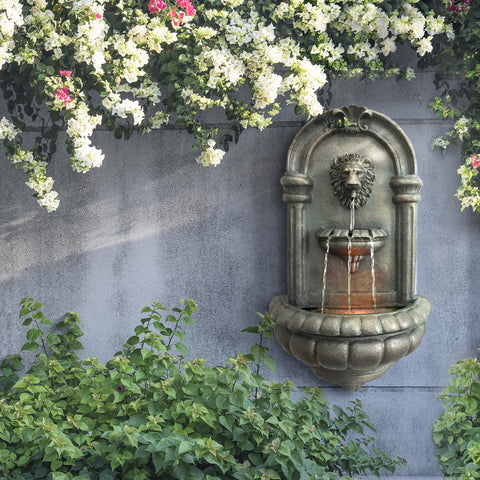 Teamson Home Lion Head Wall Fountain LED lighting highlights water at night.