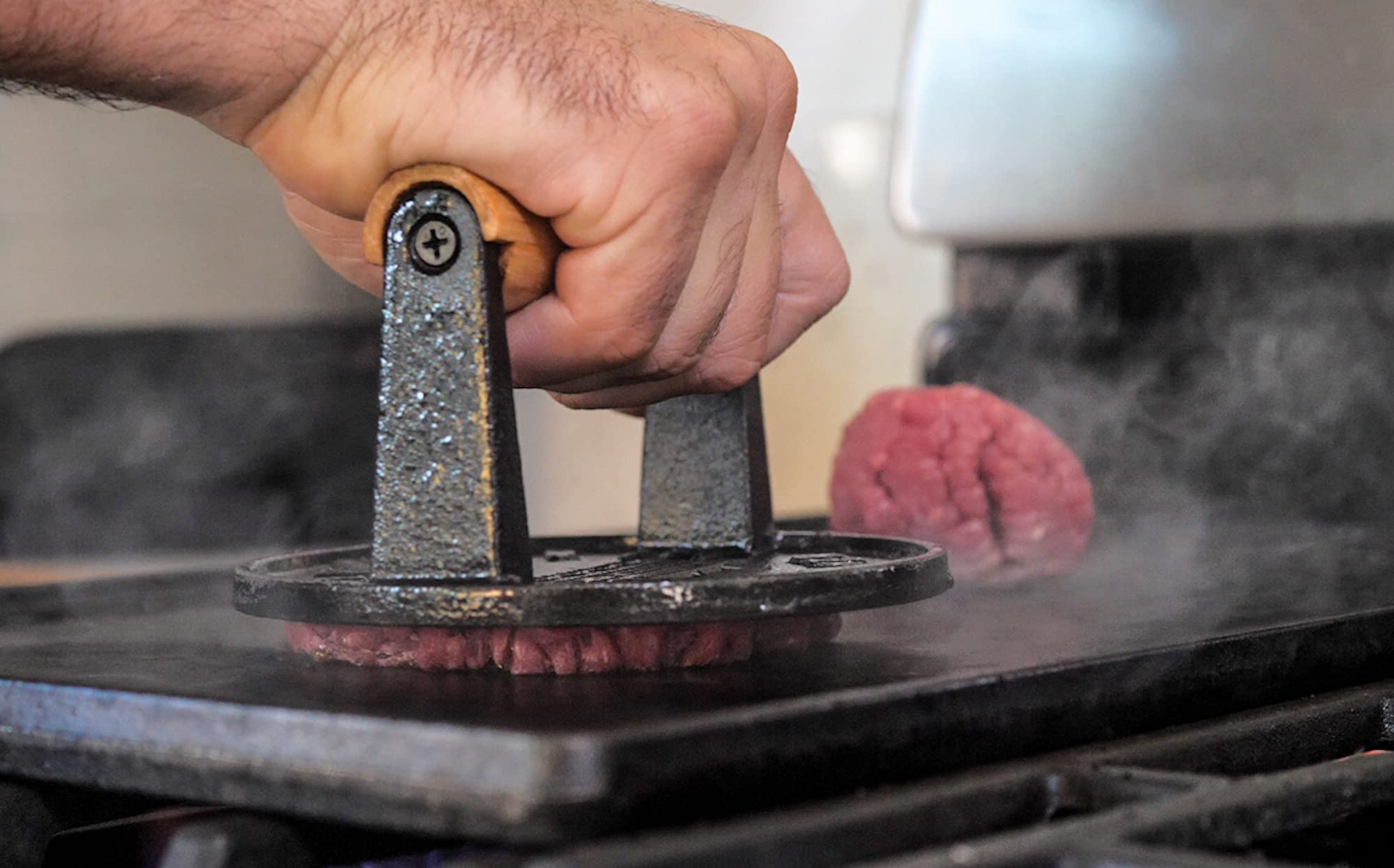 The Burger Smasher heat-resistant press withstands high temperatures on flat tops