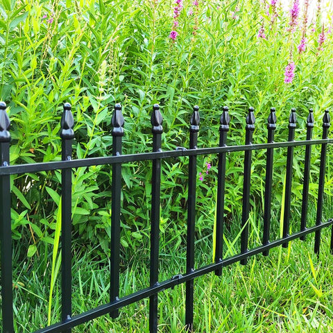 Thealyn folding fence panel forms a curved barrier around a yard area.