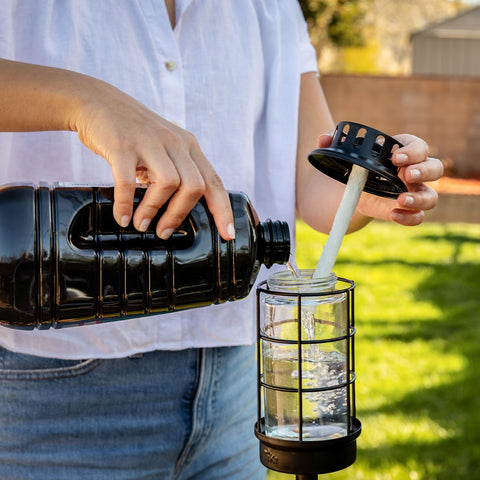 Close-up of the 100-ounce Easy Pour bottle used with TIKI torches outdoors