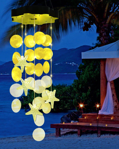 Toodour solar wind chimes outdoors with seashells provide soft illumination for a cozy garden.