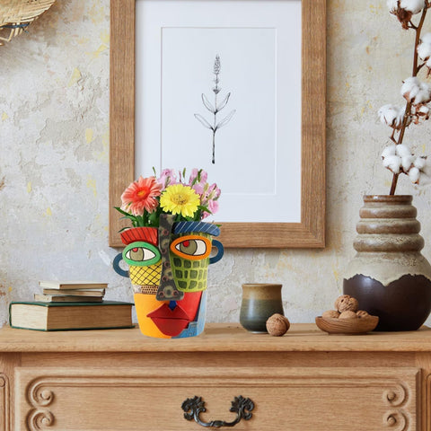 Colorful Picasso inspired head planter as a modern sculpture and plant container.