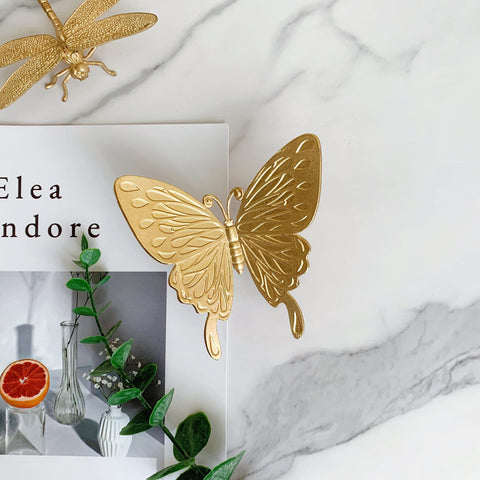 Tricune gold butterfly sculpture closeup reveals intricate metalwork and gold finish.