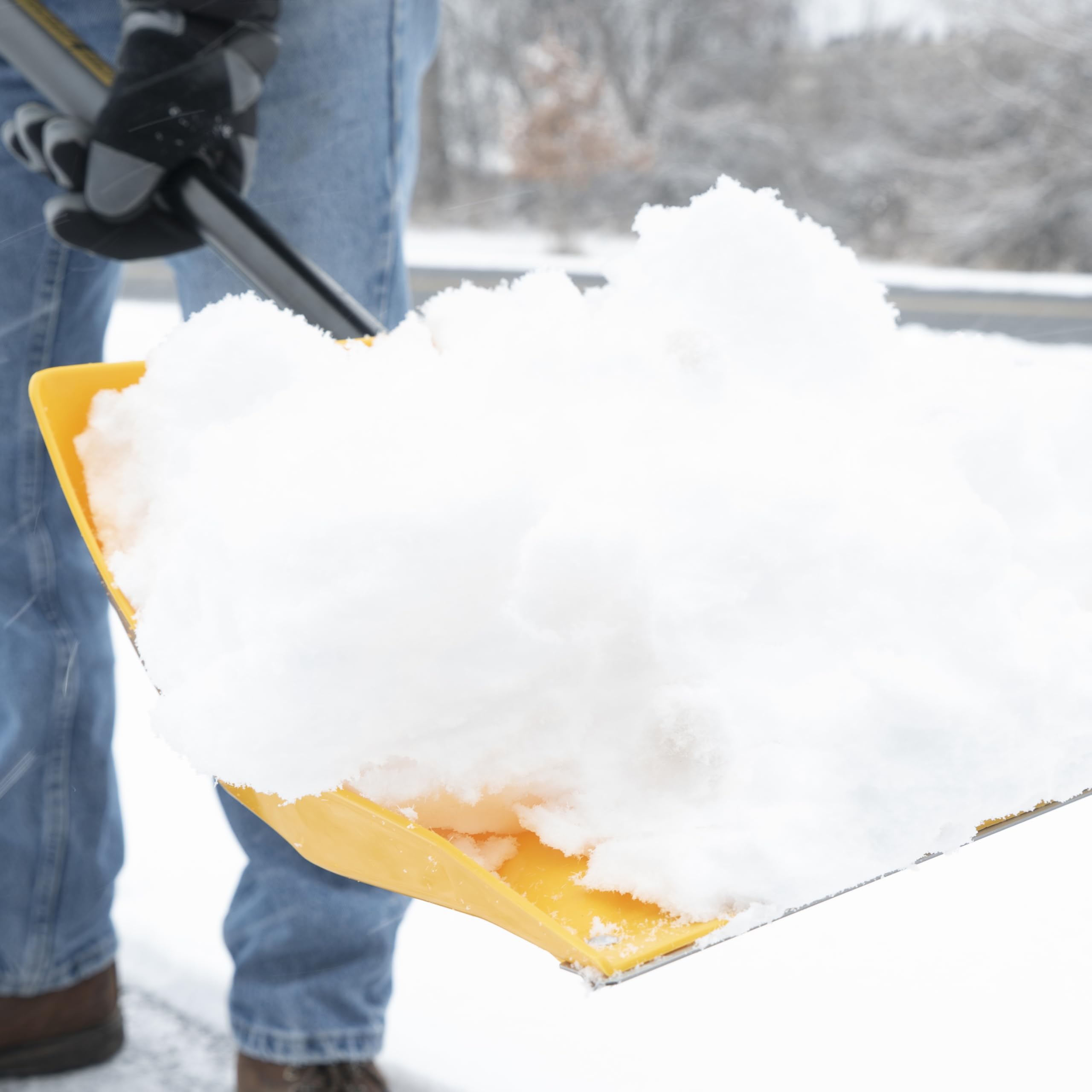 Shovel in use at a campsite next to a tent during winter conditions
